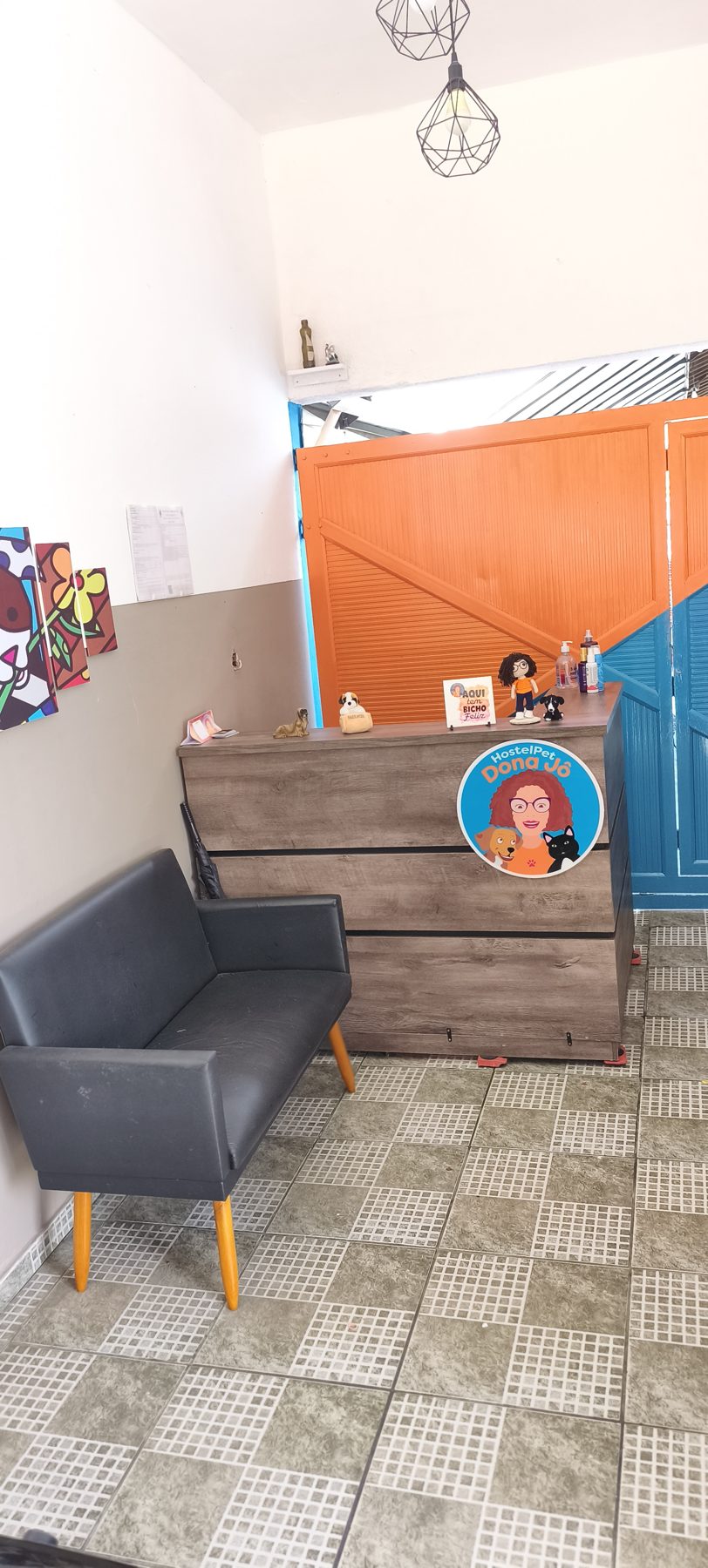 Recepção do hostel com sofá e balcão de madeira